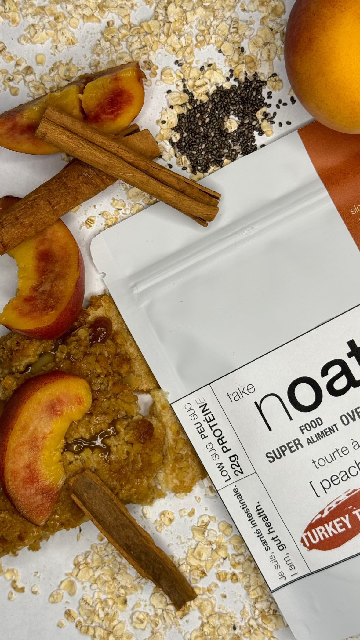 Peach Cobbler Overnight Oats pouch with peach slices and rolled oats scattered on white background