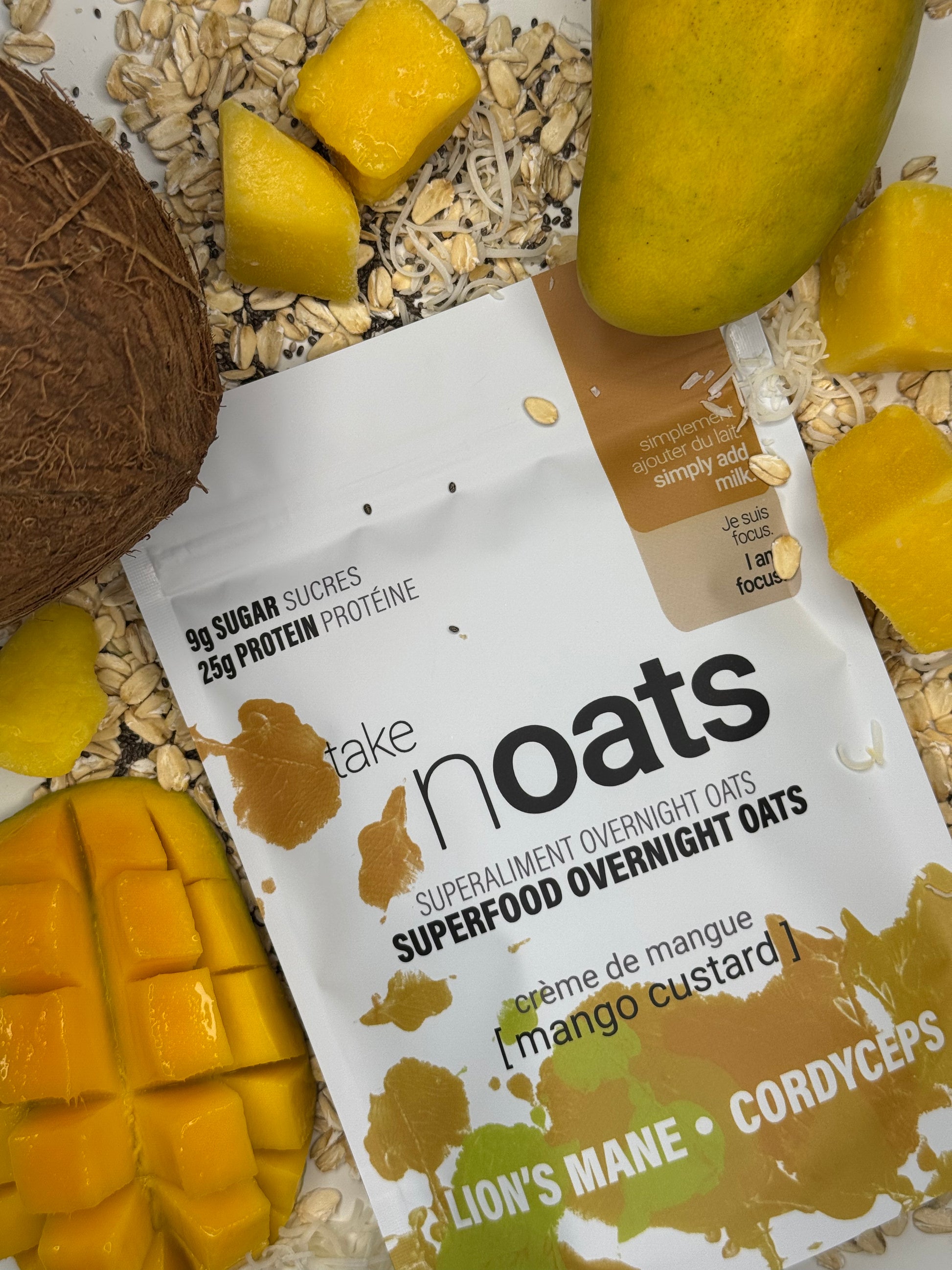 Mango Custard Overnight Oats pouch with dried mango pieces and rolled oats scattered on white background.